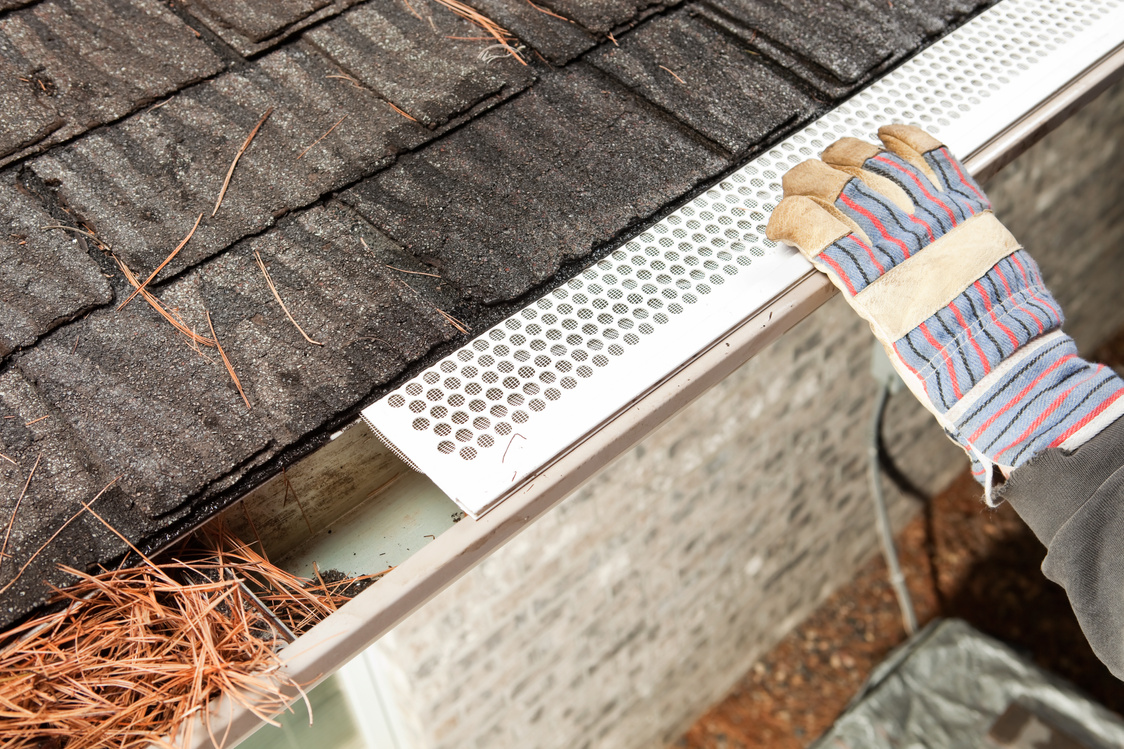 Worker Installing Rain Gutter Guard Leaf Shield