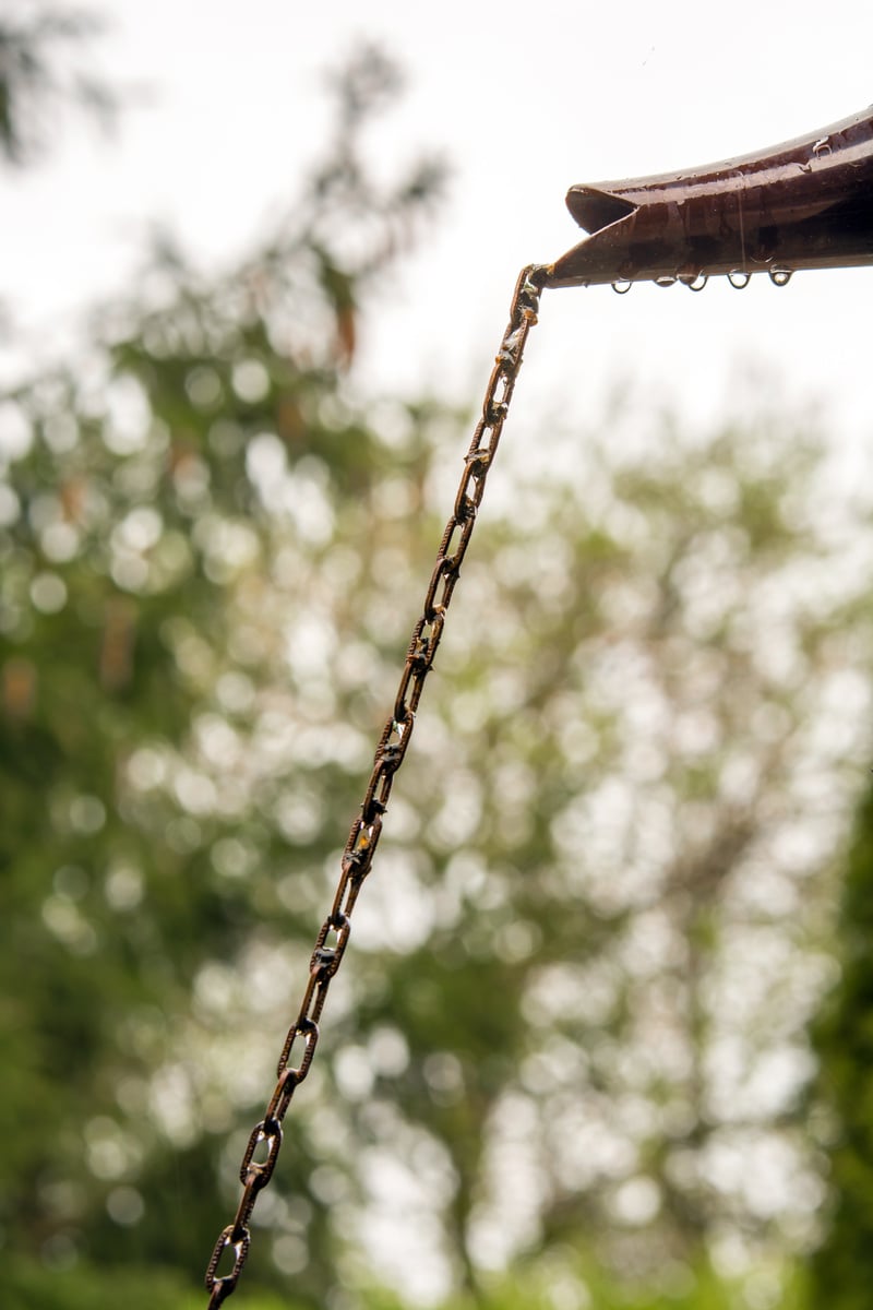 Rain drain chain chained to the gutter for a decorative and controlled drainage of rainwater